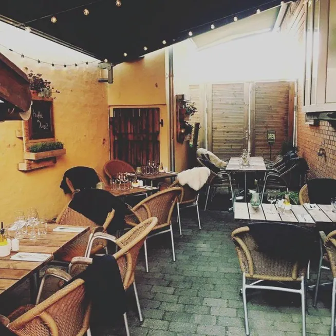 Bistroens gårdhave med kulørte lamper om aftenen
